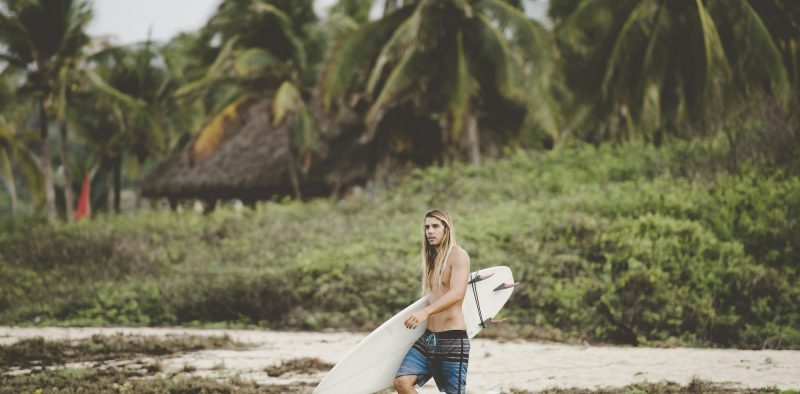 Australian surfer with surfboard, Bacocho, Puerto Escondido, Mexico